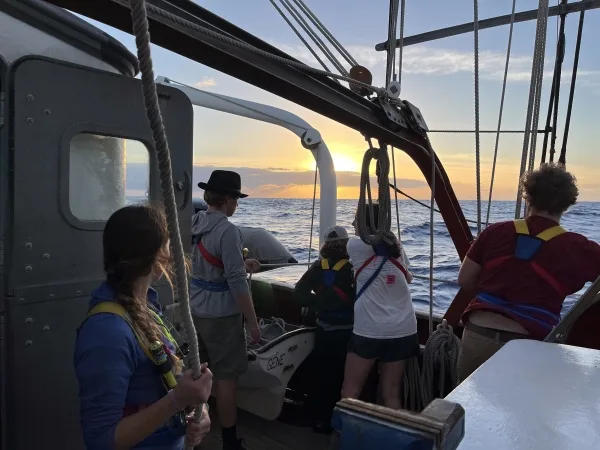 Duncan, Hannah, Sophia, Cassie, and Carson staring at the sunset on the starboard side.