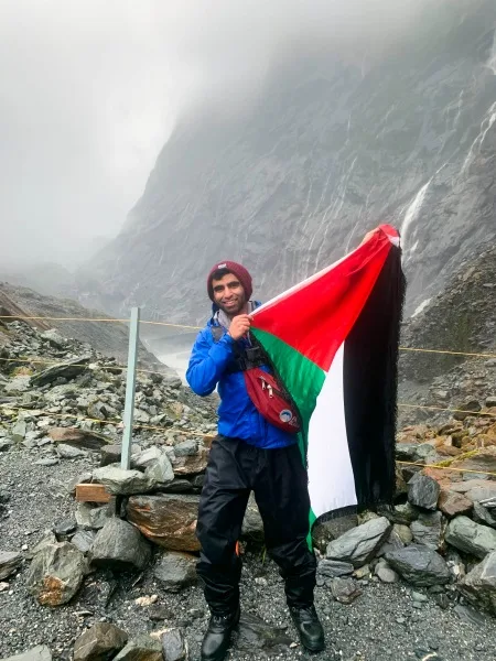 Mujahed holding the Palestinian flag at Franz Joseph Glacier.