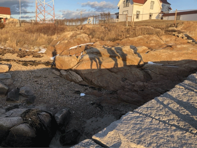 The shadow of B-House students on the rocks of Gloucester, MA