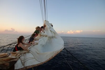 From left: Ariana, Elena, Alex (me), and Julia furling the jib at sunset on the headrig.