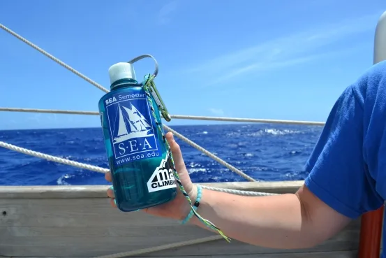 Sam holding my water bottle with her attached future friendship bracelet.