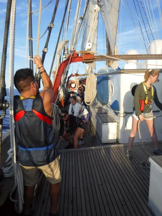 Hauling on the main halyard.