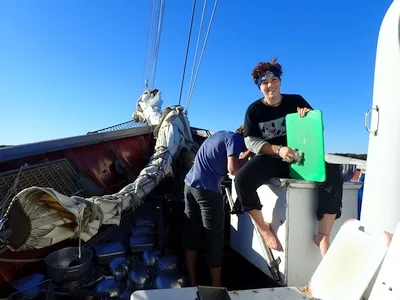 Katey cleaning galley supplies on the bow