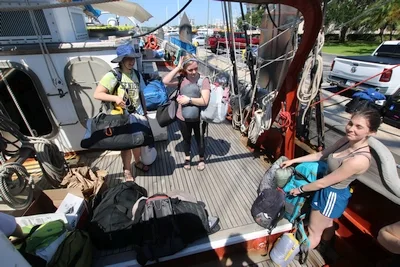 Fiona, Sydney Marie, and Ava (left to right) move their gear aboard the SSV Corwith Cramer.