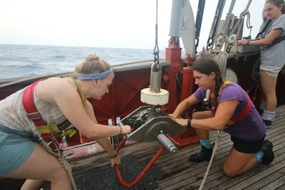 Sydney Marie (left) and Jordan (center) load the Shipek Grab for deployment to collect sediment, while Leanna (right) stands by on the hydraulic wire.