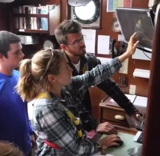 Julian looking at the radar as a shadow with our watch officer, Kate; Ashby looking on.