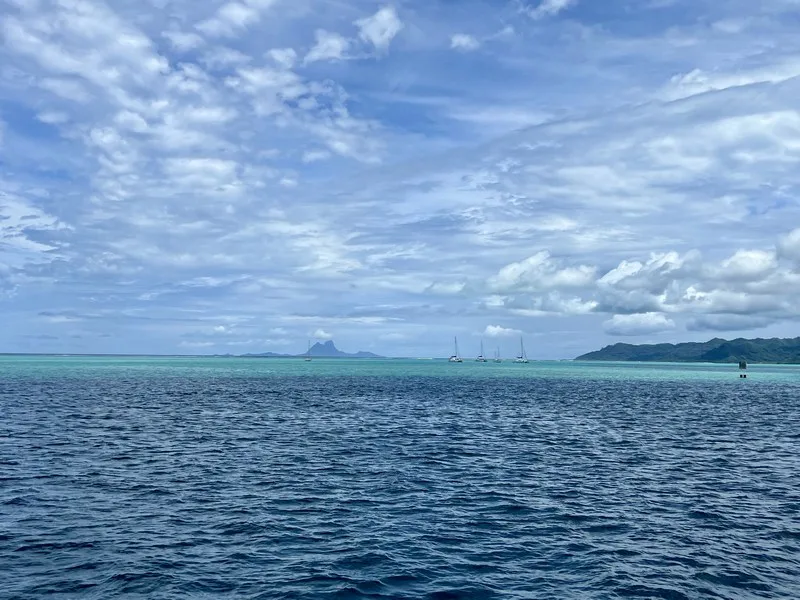 A view from the stern of the Robert C. Seamans, departing Raiatea and Taha’a (foreground and lagoon), sailing towards Bora Bora (background).